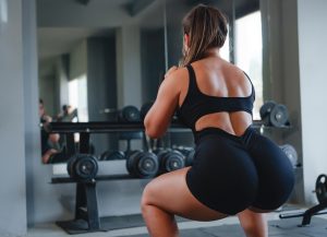 Fit woman performing a goblet squat at the gym, focusing on glute and leg muscle development