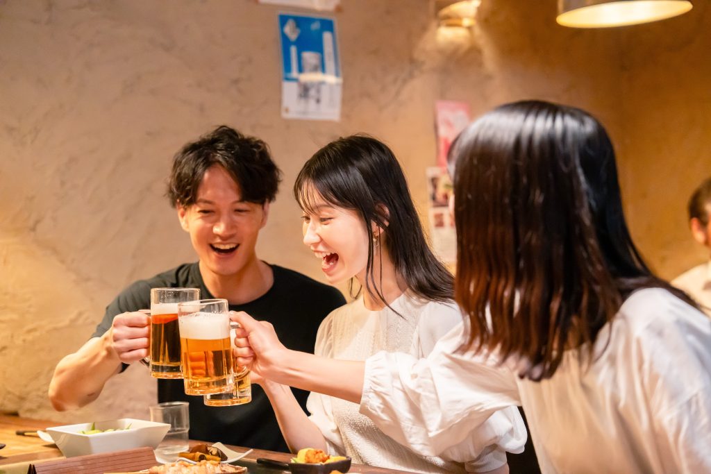 居酒屋でお酒を飲む若い男女